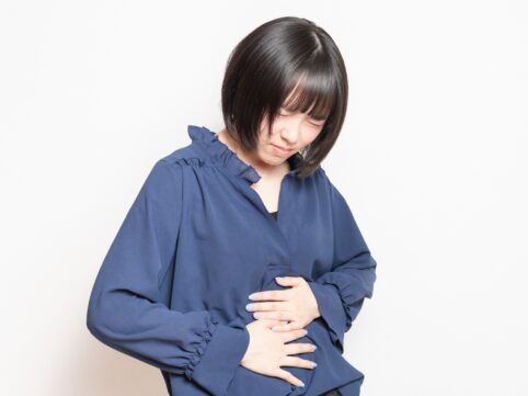 腹部を押さえる女性